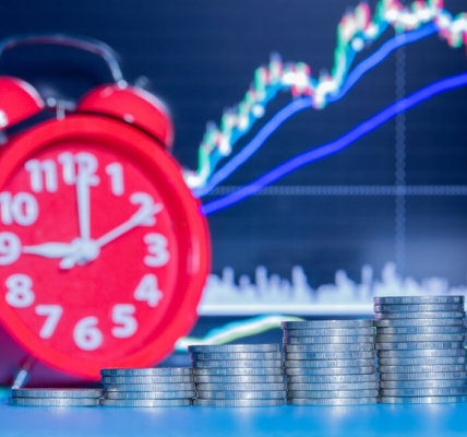 Clock, stack of coins, and market trend in the background