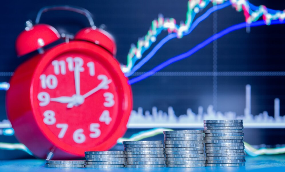 Clock, stack of coins, and market trend in the background